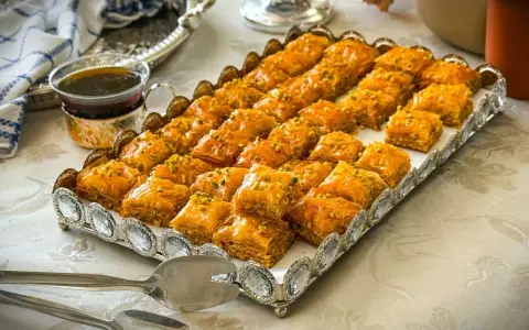 Ein Tablett voller goldbrauner Baklava, bestreut mit Pistazien. Dieses köstliche Baklava-Rezept ist perfekt für jede Feier.