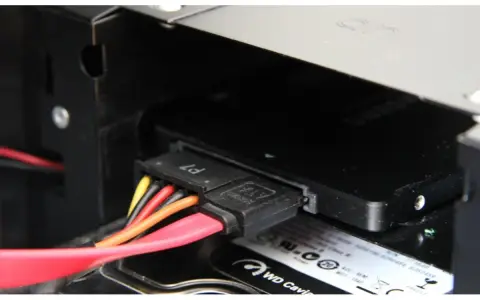 Connexion des câbles SATA pour installer un SSD dans un boîtier d'ordinateur.