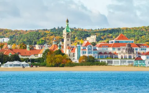 Malownicze budynki i plaża w Sopocie, idealne miejsce, by zobaczyć w Sopocie. W tle jesienne drzewa.