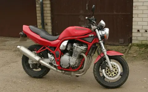 Czerwony Suzuki Bandit 600, gotowy do jazdy, z widocznym silnikiem i wydechem.