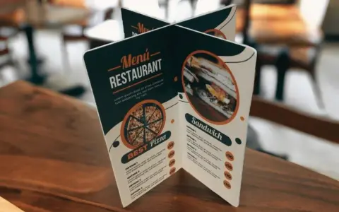 Carta de un restaurante con imágenes de pizza y sándwich. Muestra opciones de menú y precios.