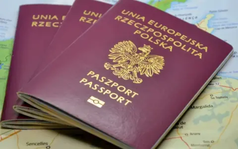 Trzy polskie paszporty leżą na mapie. Zastanawiasz się, ile czasu zajmuje wyrobienie paszportu?