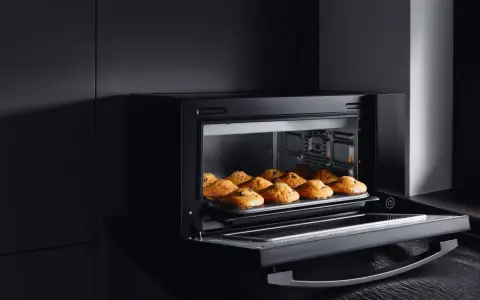 Horno de leña empotrado con bandeja de muffins recién horneados.