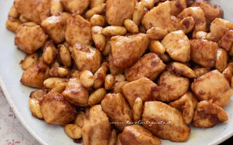 Un invitante piatto di pollo alle mandorle, con bocconcini dorati e mandorle tostate immerse in una salsa lucida.