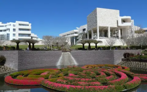 A vibrant floral maze floats in a pool before the modern architecture of the Los Angeles Center for Digital Art.
