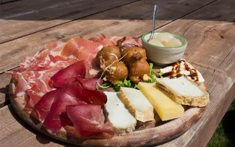 Tagliere con salumi, formaggi, frittelle e cipolline, un assaggio dei piatti tipici Valtellina.