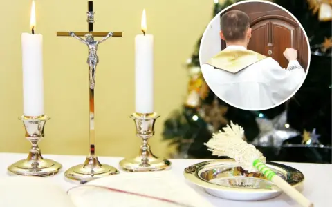 Ksiądz w białej albie puka do drzwi, rozpoczynając poświęcenie domu. Obok świece, krzyż i kropidło.