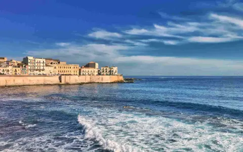 Siracusa: cosa vedere a Siracusa e dintorni in 5 giorni. La costa con palazzi storici e il mare blu.