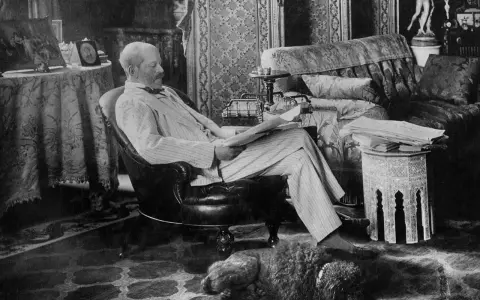 A man reads in a plush armchair, a dog sleeps nearby. The opulent room hints at the grandeur of the Rothschild art collection.