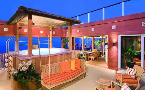 Terrazza con vasca idromassaggio e zona pranzo, un esempio di quali sono le cabine migliori su una nave da crociera.