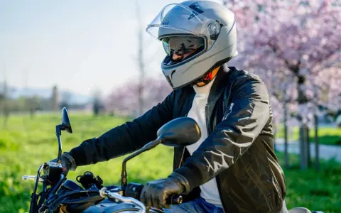 Motociclista con casco grigio, pronto per un giro. La misura testa è perfetta per la sicurezza.