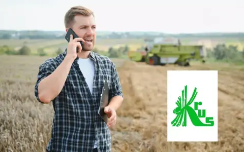 Rolnik rozmawia przez telefon na polu, planując, jak założyć firmę na krusie. W tle kombajn zbiera plony.