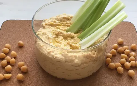 Pyszny, kremowy hummus z ciecierzycy, idealny do maczania łodyg selera. Oto co to jest hummus – zdrowa przekąska!