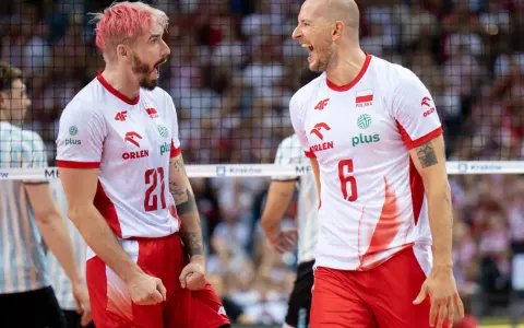 Dwóch zawodników siatkówka polska w biało-czerwonych strojach świętuje punkt. Jeden z różowymi włosami, drugi łysy, obaj krzyczą z radości.