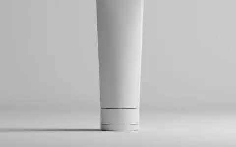 Tubo bianco minimalista, con un sottile anello scuro, che contiene una formula con hydroxypropyl starch phosphate per una pelle liscia.