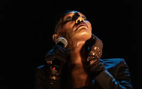 Grace Jones idag, med mikrofonen i handen och blicken uppåt, utstrålar ikonisk scenenergi.