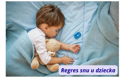 Małe dziecko śpi z misiem, otulone błękitnym kocykiem. Obok smoczek. To może być moment regresu snu u dziecka.