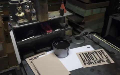 Co to jest print? To ręcznie drukowany plakat "LINOTYPE FOR LIFE" z użyciem czarnego tuszu, drewna i maszyny Linotype.
