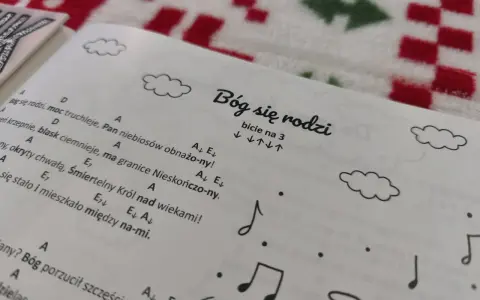 Śpiewnik z kolędami na ukulele. Na stronie tytuł "Bóg się rodzi" i nuty.