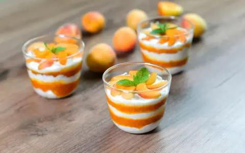 Cremige Desserts mit Aprikosenmus und Sahne, garniert mit frischen Aprikosenstücken und Minze. Eine köstliche Alternative zu shaved ice.