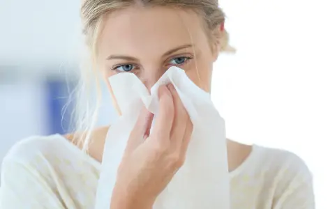 Donna con fazzoletto nasale, forse soffre di allergia aria condizionata.