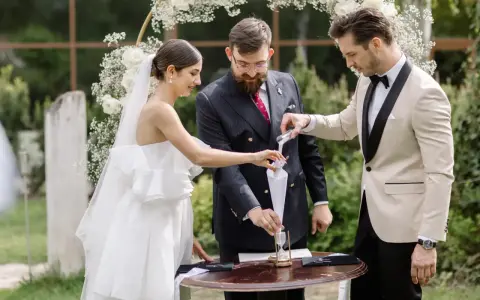 Para młoda podczas ceremonii, w tle łuk weselny. Zastanawiasz się nad wedding planner cena?