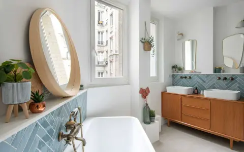 Salle de bain moderne avec carrelage zellige bleu canard, baignoire, double vasque sur meuble vintage et miroir rond en bois. Inspiration zellige.