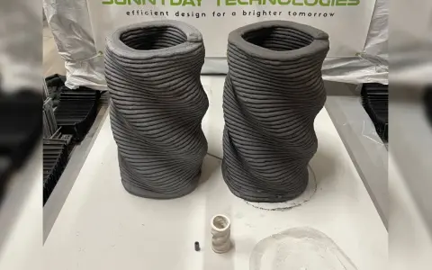Dos jarrones retorcidos creados mediante impresión 3D hormigón. Se aprecian las capas de material.