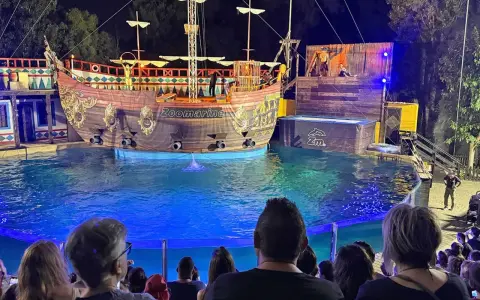 A pirate ship show at Zoomarine Roma with performers on a stage and in the water.