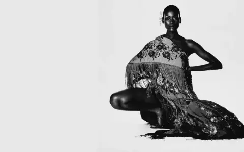 Irving Penn captura a una modelo agachada con un chal bordado y flecos.