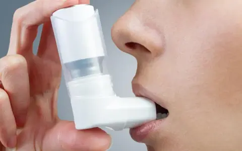 Osoba używa inhalatora Ventolin na astmę, by ułatwić oddychanie.