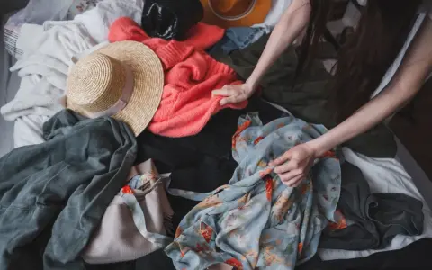 Przesądy związane z rzeczami po zmarłych, jak buty, mogą budzić niepokój. Na zdjęciu widać stos ubrań, wśród nich kapelusze i swetry.