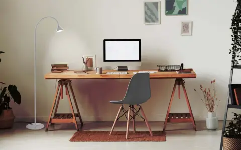 Bureau moderne pour le télétravail : bureau en bois, ordinateur, plante verte et lampe. Une belle idée bureau teletravail pour un espace fonctionnel et agréable.