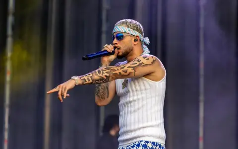El artista dei v Málaga, con tatuajes y bandana, canta en el escenario.
