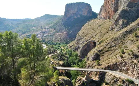 Un puente cruza un cañón con un pueblo en la ladera. El **mirador del infierno** ofrece vistas espectaculares de la garganta y las montañas.