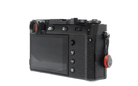 Czarne body aparatu Fujifilm X100S z widocznym ekranem, przyciskami i uchwytem na pasek.