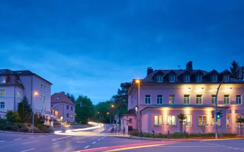 Parkhotel Güldene Berge in Harz bei Nacht, mit Lichtern und Spuren von Autos.