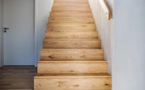 Holztreppe mit beleuchteten Treppenstufen verkleiden. Natürliche Holzmaserung und schlichtes Design.