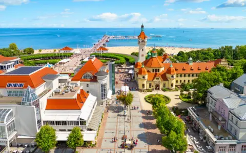 Malownicze miejscowosci nad morzem z molo, plażą i zabytkową architekturą.