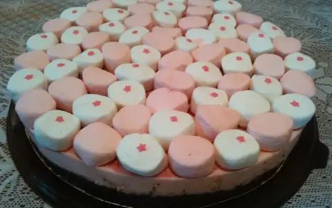 Tarta de nubes de golosina, cubierta con malvaviscos rosas y blancos, cada uno con una pequeña estrella roja.