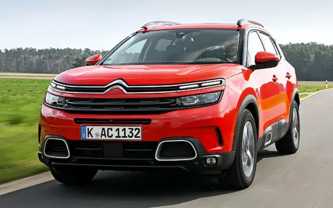 Roter Citroën C5 Aircross fährt auf einer Landstraße. Trotz seines modernen Designs gibt es Berichte über Citroën C5 Aircross Probleme.