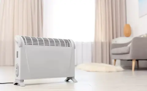 Ein weißer Elektroheizer steht im Wohnzimmer. Er hilft, die strom heizung kosten pro monat im Blick zu behalten.