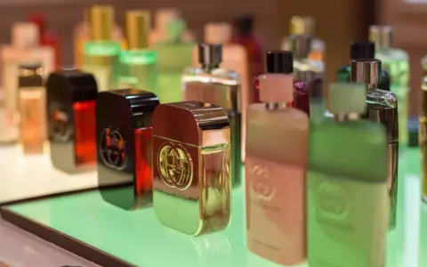 Butelki perfum Gucci Guilty na zielonym podświetlanym tle.