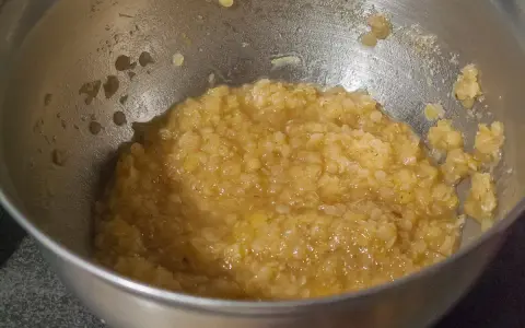 Un bol en métal contient une purée de lentilles corail, prête à être cuisinée.