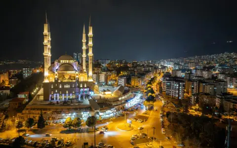 Piękny meczet nocą, oświetlony i otoczony miastem. Warto wiedzieć, ramadan co to za święty czas.