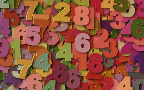 Kolorowe cyfry tworzą tło. Wśród nich wyróżnia się liczba 8, symbolizująca rok numerologiczny 8, moc i sukces.