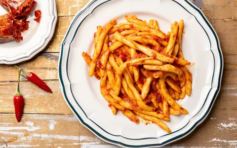 Piatto di pasta con nduja e peperoncini rossi, un classico saporito.