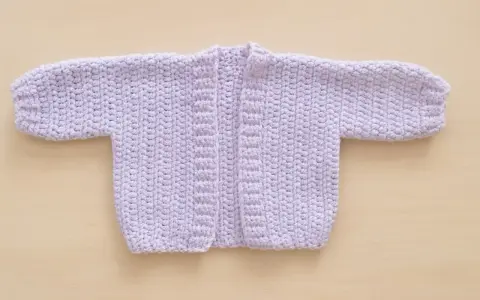 Chaqueta de bebé tejida a mano, color lila. Ideal para 6 meses, con un diseño sencillo y cálido.