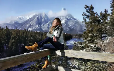 Ragazza con gita outfit montagna estate, gode del panorama innevato.