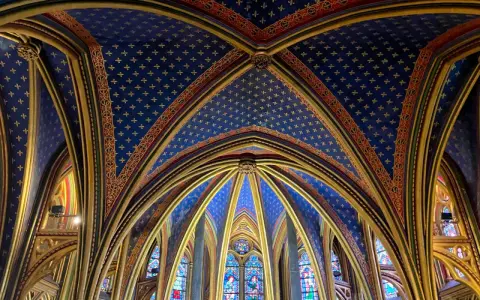 Techo abovedado de la Sainte-Chapelle, con intrincados detalles dorados y un cielo azul estrellado.